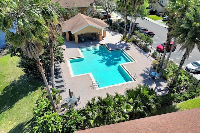 community pool with a patio and fence