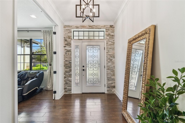 foyer featuring a notable chandelier, hardwood / wood-style flooring, baseboards, and ornamental molding