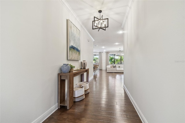 hallway with dark wood-style floors, baseboards, and a chandelier