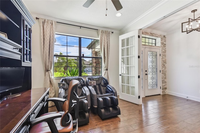 home office with baseboards, wood finished floors, crown molding, and ceiling fan with notable chandelier