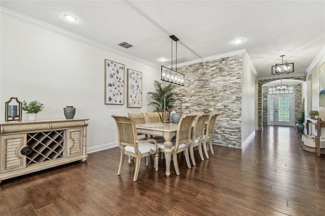 dining space featuring baseboards, visible vents, dark wood finished floors, ornamental molding, and a chandelier