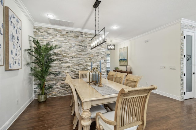 dining room featuring visible vents, baseboards, wood finished floors, and crown molding