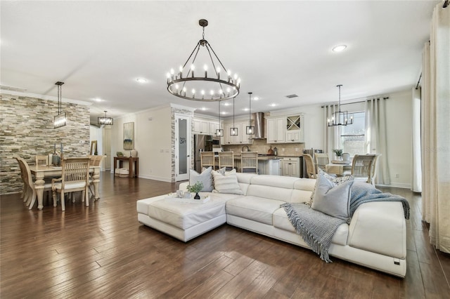 living area featuring dark wood-style floors, a chandelier, crown molding, and baseboards