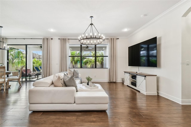 living area featuring wood finished floors, baseboards, recessed lighting, ornamental molding, and a chandelier