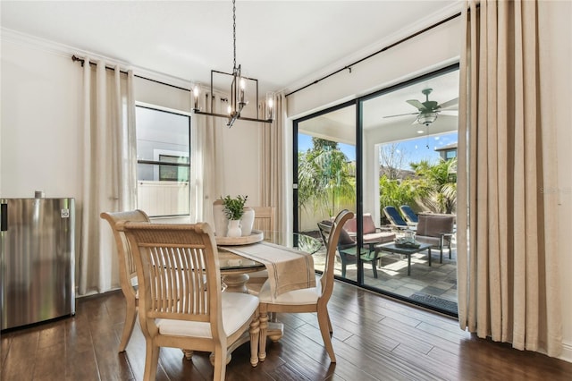 dining space with dark wood-type flooring and ceiling fan with notable chandelier