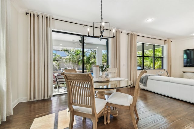 dining area featuring ceiling fan with notable chandelier, crown molding, and wood finished floors