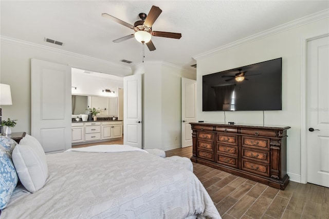 bedroom with visible vents, crown molding, and wood finish floors