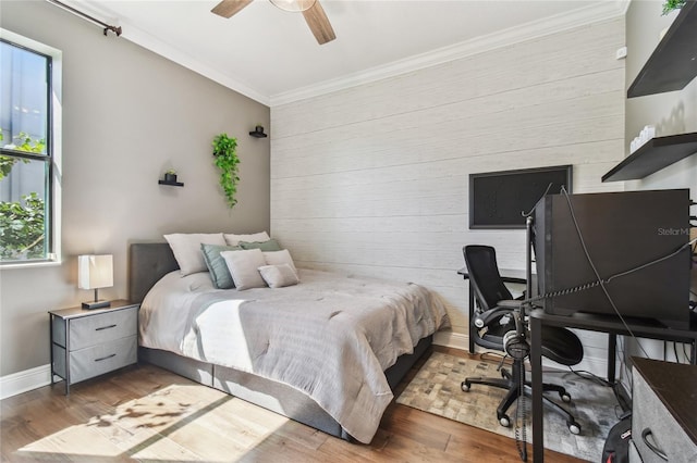 bedroom with ceiling fan, baseboards, wood finished floors, and ornamental molding