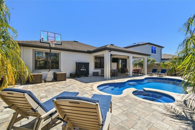 outdoor pool featuring a patio area and an in ground hot tub