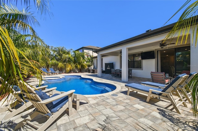 pool featuring a patio area, outdoor dining area, and a ceiling fan