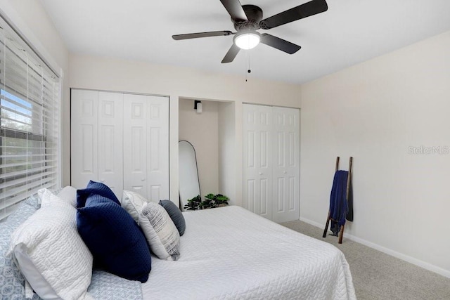 bedroom featuring ceiling fan, baseboards, multiple closets, and carpet floors