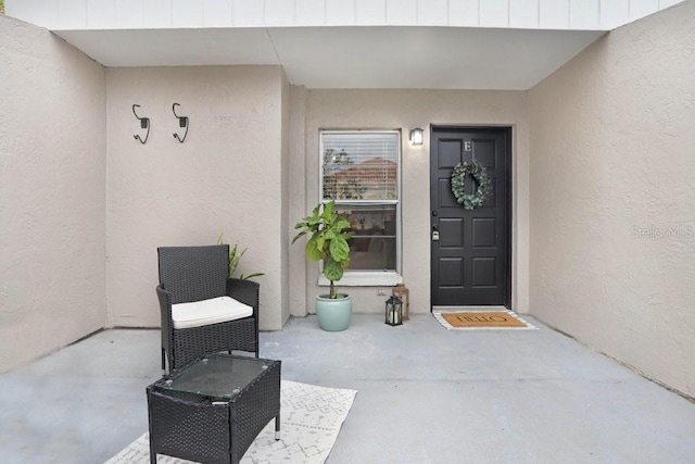 entrance to property with a patio area and stucco siding