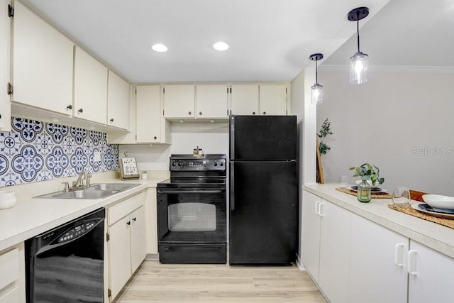 kitchen with black appliances, light countertops, light wood-style floors, and a sink