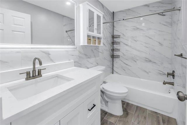 bathroom featuring wood tiled floor, bathing tub / shower combination, toilet, and vanity