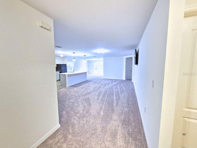 unfurnished living room with baseboards and light carpet