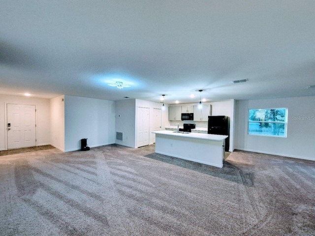 unfurnished living room featuring carpet flooring, baseboards, visible vents, and a textured ceiling