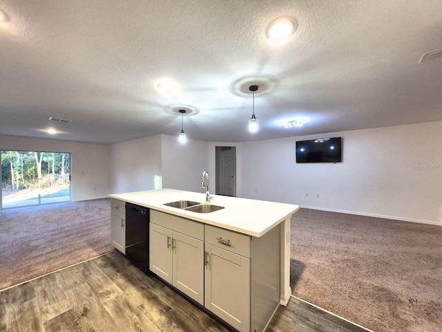 kitchen with visible vents, a sink, open floor plan, black dishwasher, and a kitchen island with sink