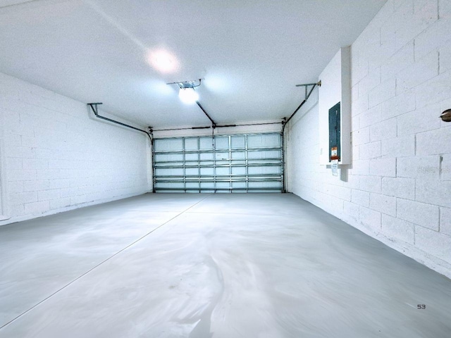 garage featuring electric panel and concrete block wall