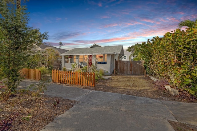 view of front facade featuring stucco siding, a fenced front yard, and a gate