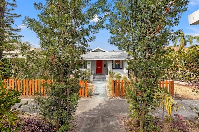 bungalow-style house with a fenced front yard and roof with shingles