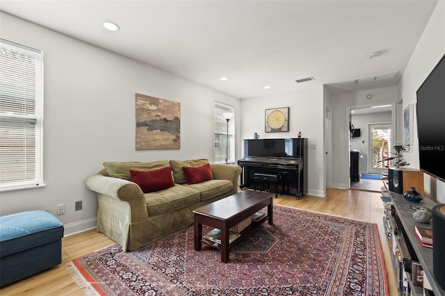 living room featuring recessed lighting, visible vents, baseboards, and light wood-style flooring