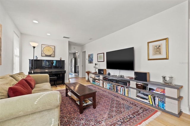 living area with recessed lighting, wood finished floors, visible vents, and baseboards