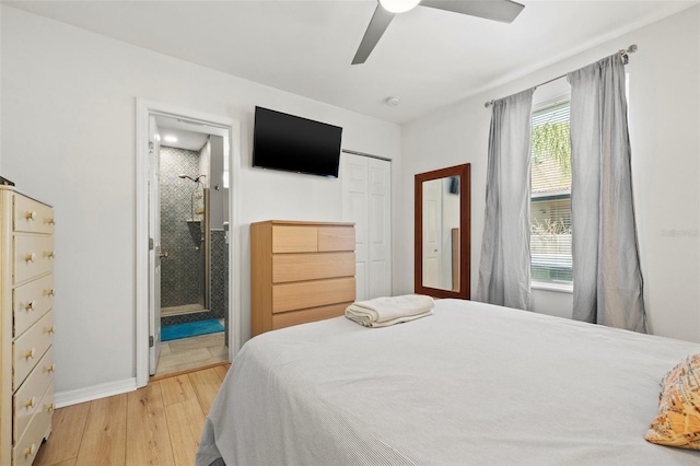 bedroom with light wood-type flooring, a ceiling fan, ensuite bath, a closet, and baseboards