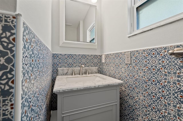 bathroom featuring a wainscoted wall, tile walls, and vanity