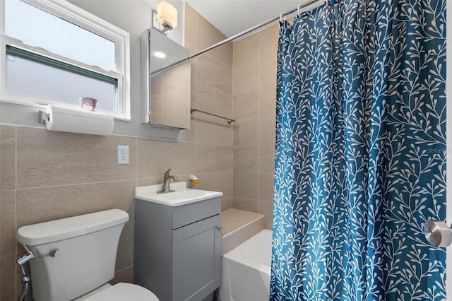 bathroom with vanity, tile walls, toilet, and shower / tub combo with curtain