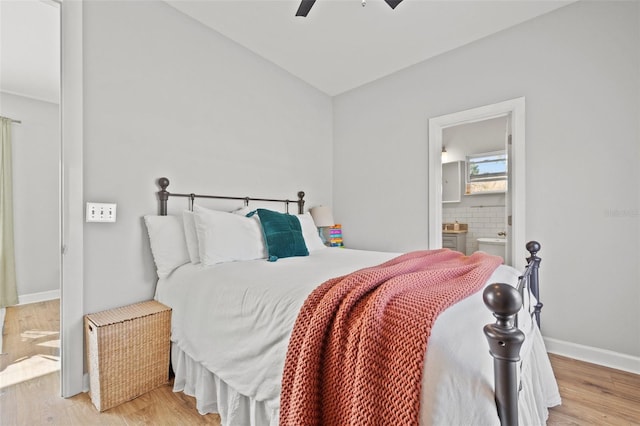 bedroom featuring baseboards, a ceiling fan, wood finished floors, and ensuite bathroom