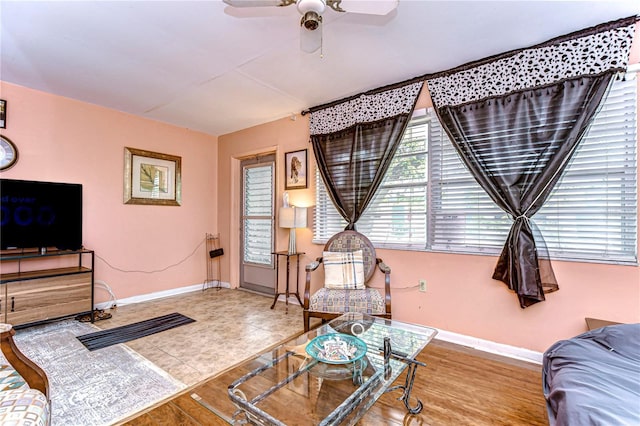 living room with baseboards and ceiling fan