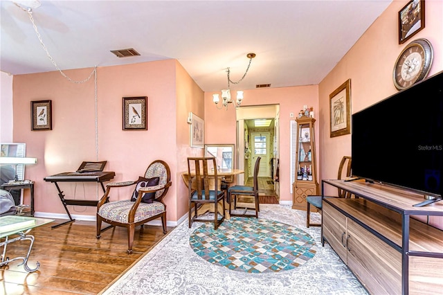 sitting room featuring a notable chandelier, wood finished floors, visible vents, and baseboards