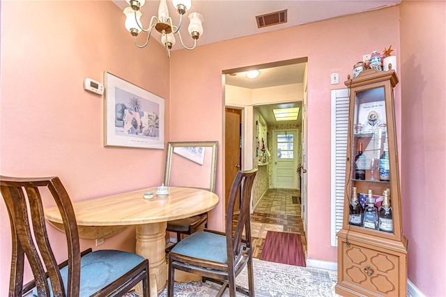 dining area with visible vents and an inviting chandelier