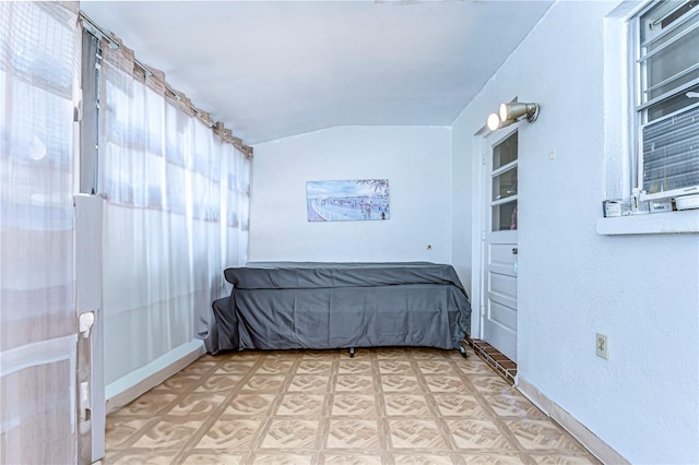 unfurnished bedroom with lofted ceiling and light floors