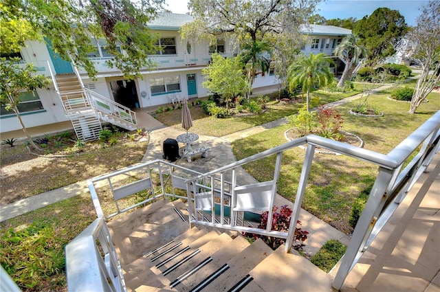 surrounding community with stairs and a yard