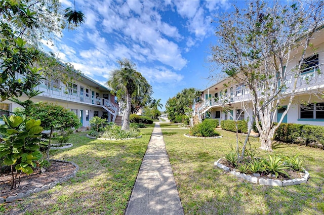 view of community with a lawn and stairs