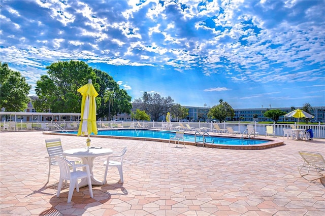 community pool featuring a patio area and fence