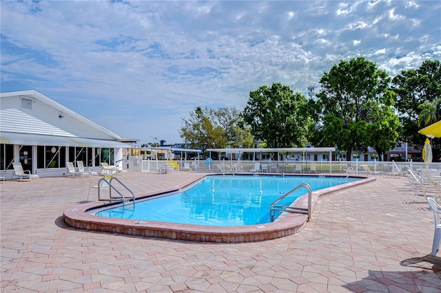 community pool featuring a patio area and fence