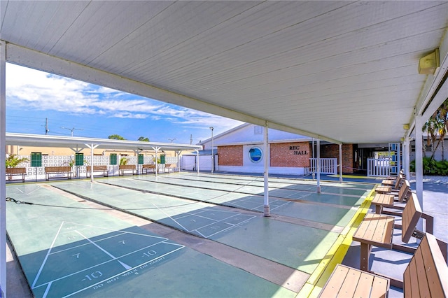 view of property's community featuring shuffleboard and fence