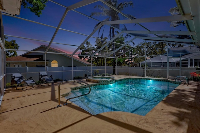 pool at dusk featuring glass enclosure, a pool with connected hot tub, a patio, and fence