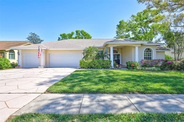 view of front of property with stucco siding, an attached garage, driveway, and a front yard