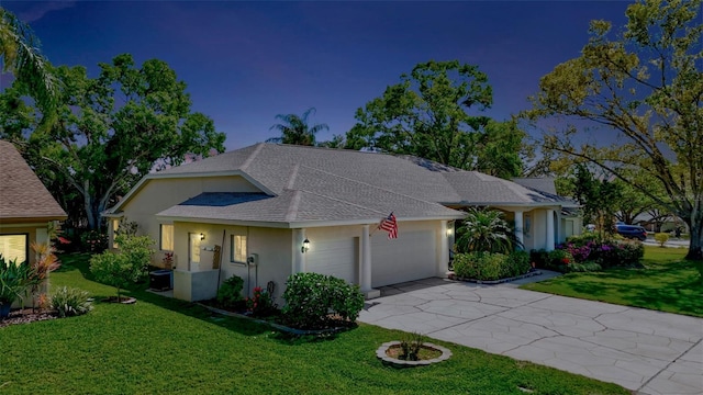 view of front facade with stucco siding, driveway, a front lawn, and a garage