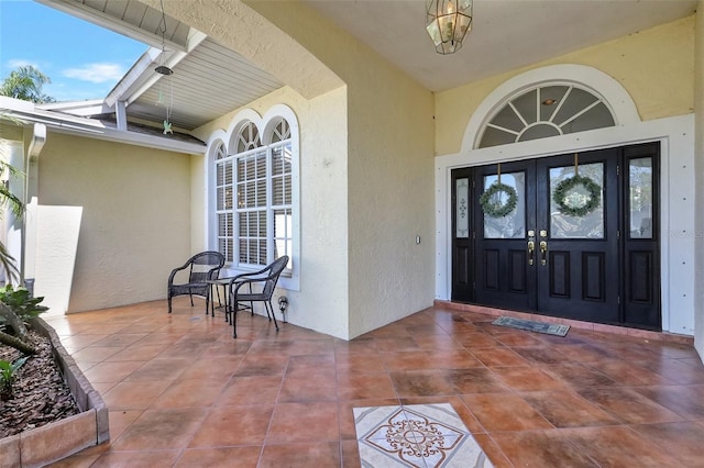 exterior space featuring lofted ceiling with beams, tile patterned flooring, and a textured wall