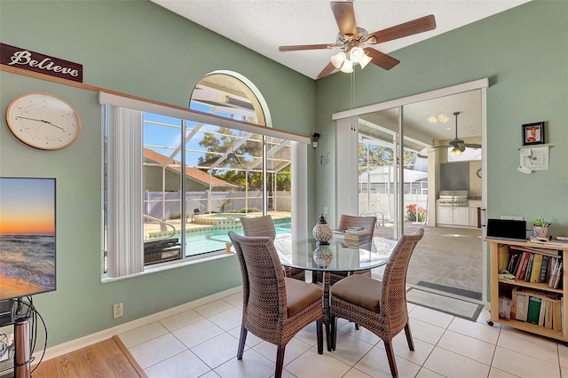 dining room featuring baseboards, ceiling fan, and tile patterned flooring