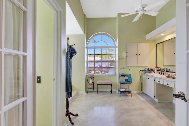 bathroom featuring high vaulted ceiling, baseboards, vanity, and a ceiling fan