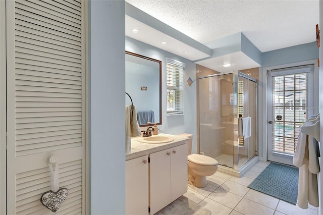 full bath with tile patterned flooring, a shower stall, a textured ceiling, and vanity