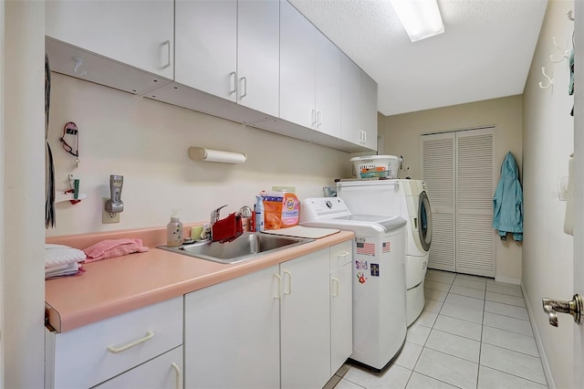 laundry room featuring independent washer and dryer, a sink, a textured ceiling, cabinet space, and light tile patterned flooring