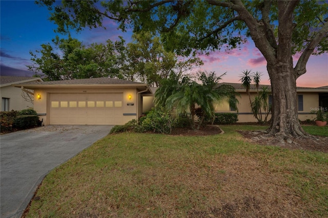 view of front of house featuring a front lawn, concrete driveway, a garage, and stucco siding