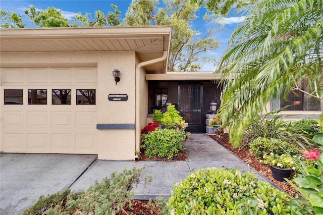 view of exterior entry featuring stucco siding and a garage