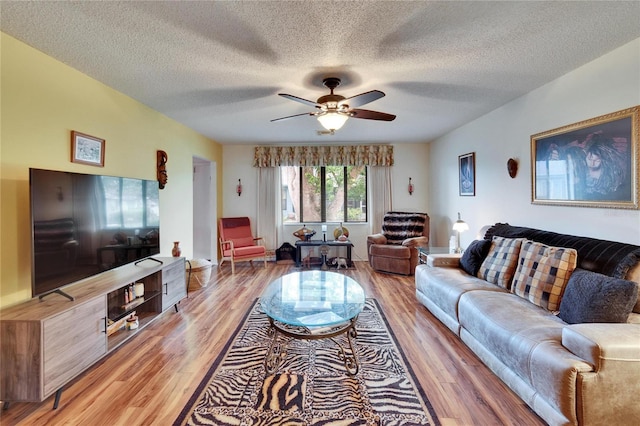 living area with a textured ceiling, a ceiling fan, and light wood finished floors